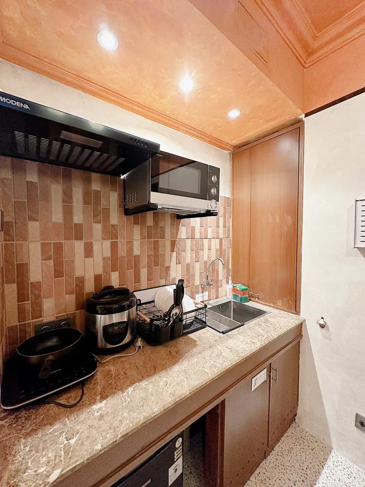 Melbourne: Open kitchen: induction stove, cooker hood, rice cooker and fridge.