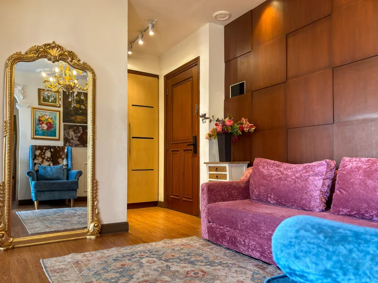 Marseille: A gilt full-length mirror by the entrance, the sofa beside it.