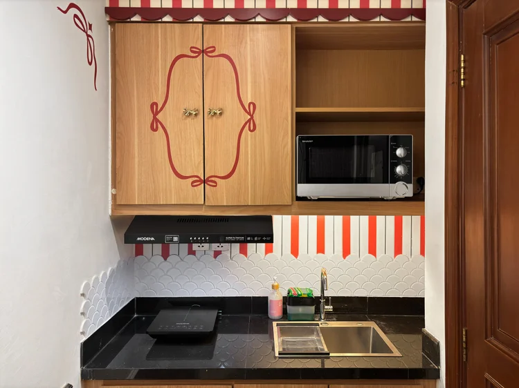 Chamonix: Kitchen with cherry-print cabinets and a microwave; the lobby convenience store sells the basics for cooking.