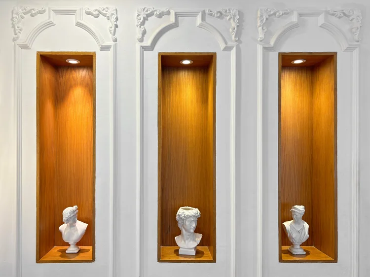 Paris: Niches with busts and warm lighting, a Parisian touch in the living room.