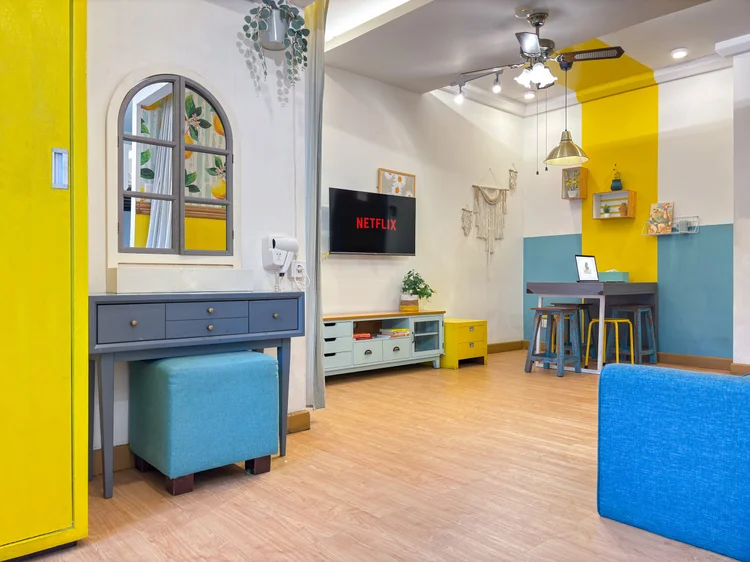 St. Tropez: A Summer-themed studio: yellow and blue accents, a dressing table by the door, the living area beyond.