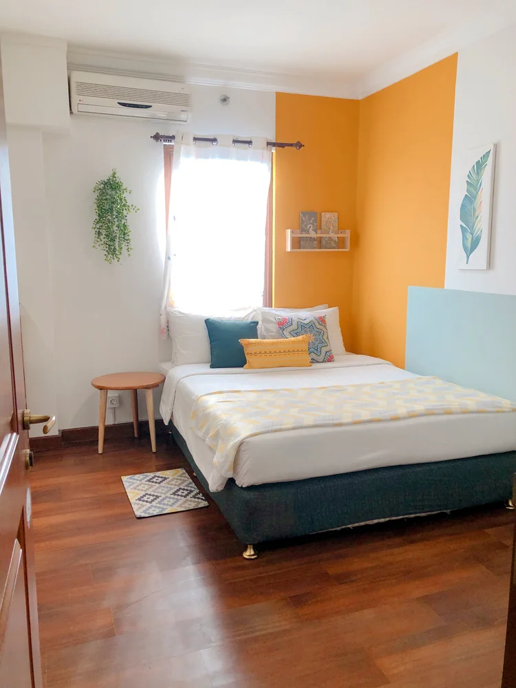 Havana: Master bedroom: a 160 cm queen bed with AC and a bright yellow wall.