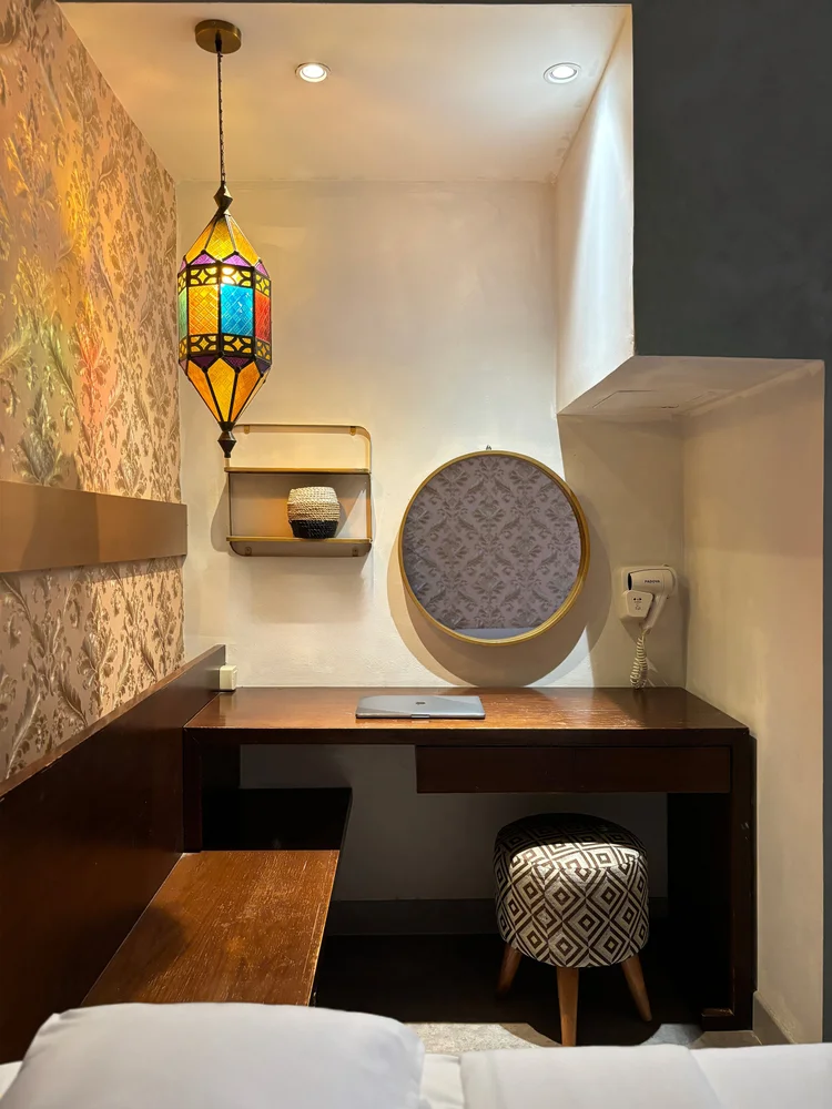 Marrakech: Dressing table with round mirror and stool; the wardrobe is in the same room.