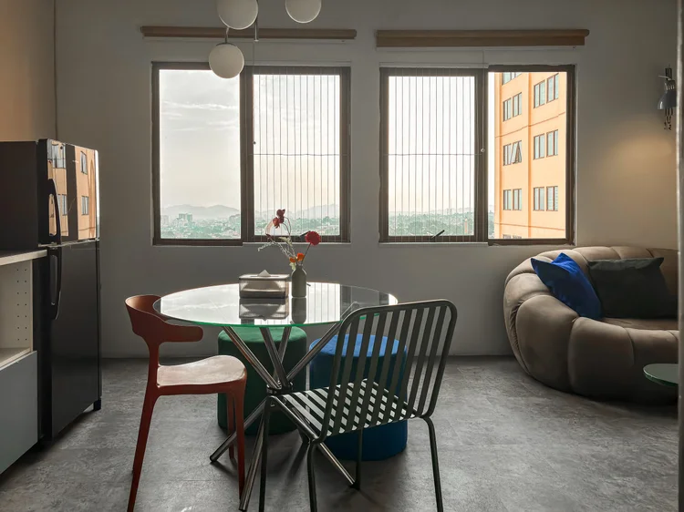 Vancouver: A glass dining table for four by the window, the fridge close by.