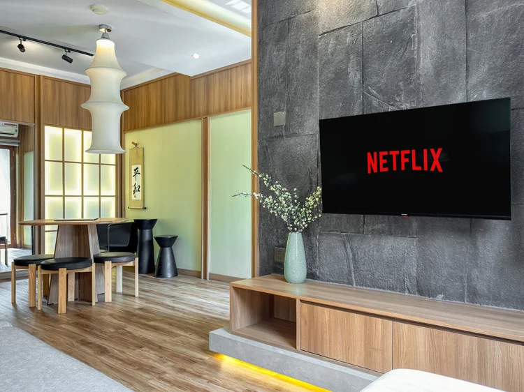 Sapporo: Smart TV with Netflix on the stone wall, softly lit shoji panels beside it.