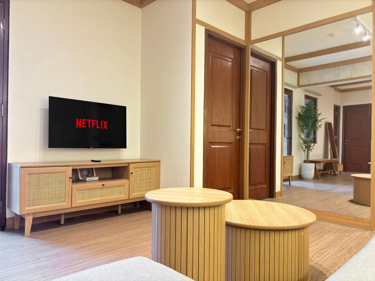 Nara: TV with Netflix on a rattan credenza, facing the sofa.