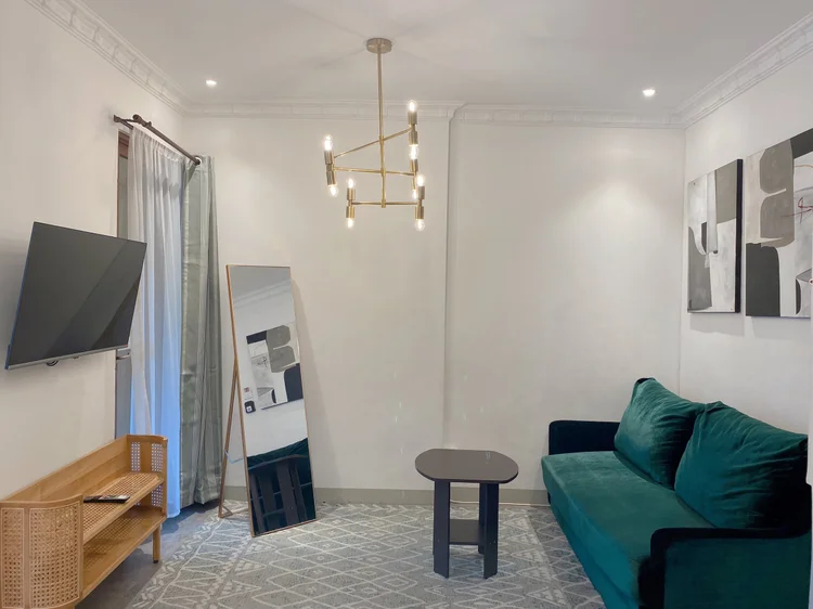 Budapest: The Modhemian living room: green sofa, smart TV and a chandelier.