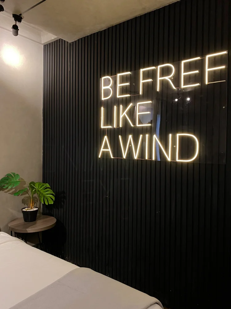 Kingston: The Be free like a wind neon on the black wall, Kingston's signature.