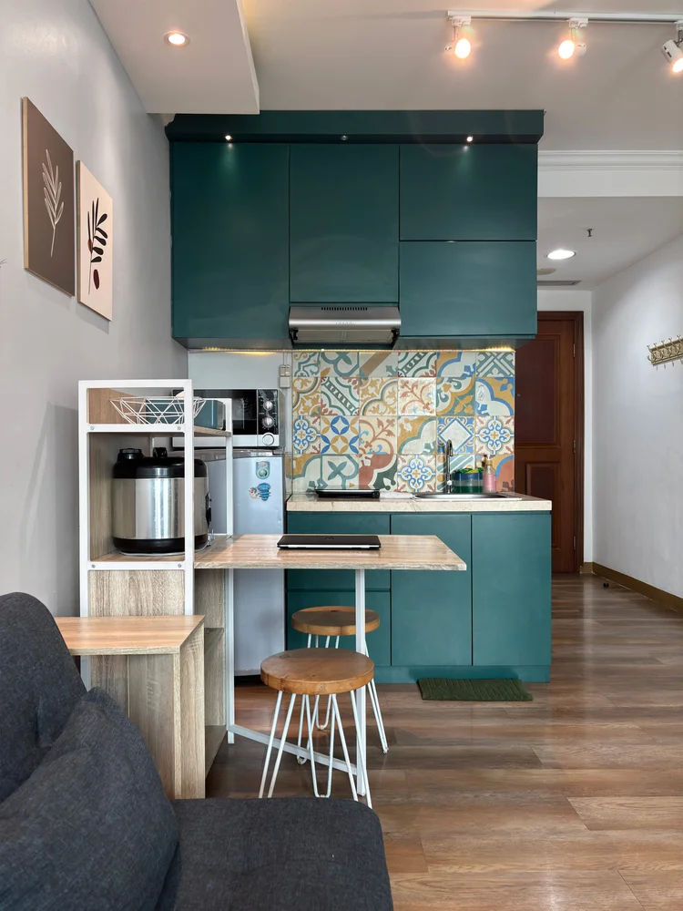 Bern: Kitchen with an induction stove, a microwave and a small dining table for two.