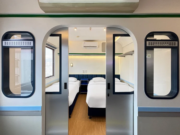 Dae Jeon: The sliding doors open to the bedroom, with two blue-trimmed beds.