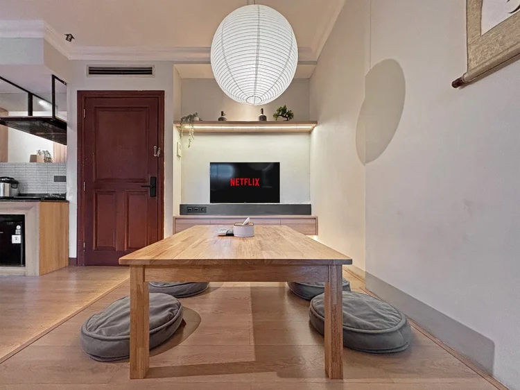 Nagoya: A low dining table for four, the open kitchen right behind it.
