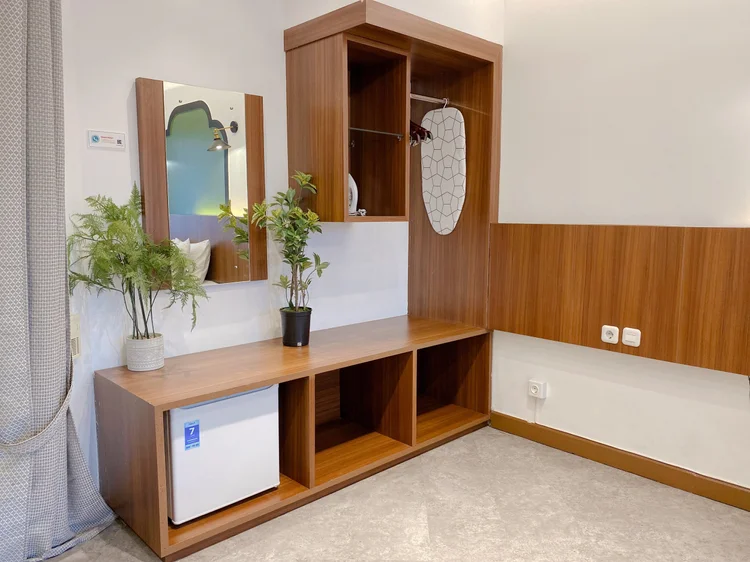 Saigon: Open wardrobe with a mirror, shelves and a small fridge underneath.