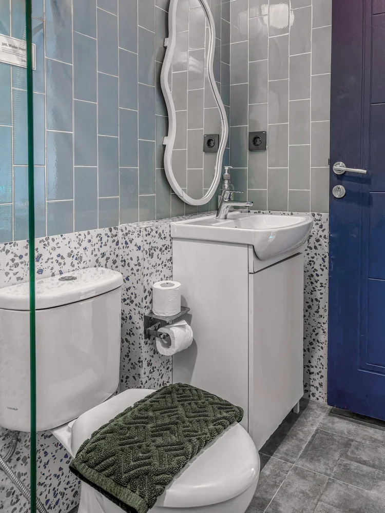 Vancouver: A modern bathroom with a wavy mirror, soap and shampoo stocked.