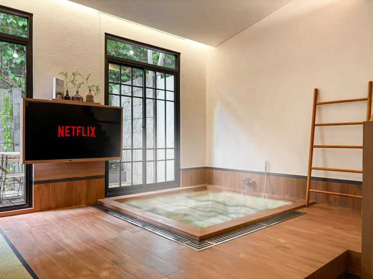 Shizuoka: A 55-inch smart TV with Netflix, the ofuro beside it.