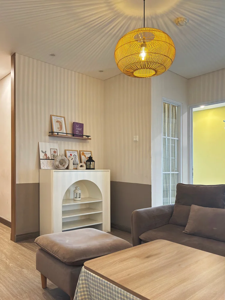 Seoul: A corner of the living room with wall shelves and an arched niche, under a rattan pendant.